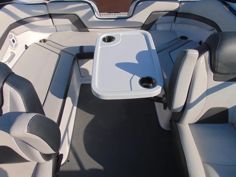 Slide: The Image of 2020 Yamaha AR240 boat interior with seating and table, featuring cup holders. - 13