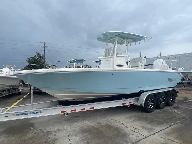 Slide: The Image of 2025 Pathfinder 2400 TRS boat on trailer, light blue hull, parked outdoors. - 1