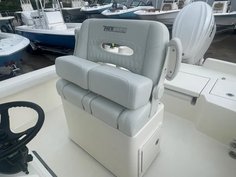 Slide: The Image of 2025 Pathfinder 2400 TRS boat seat, gray upholstery, docked with other boats in background. - 12