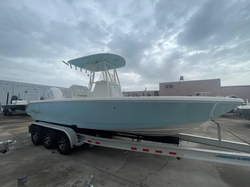 Slide: The Image of 2025 Pathfinder 2400 TRS boat on trailer, parked outdoors under cloudy sky. - 2