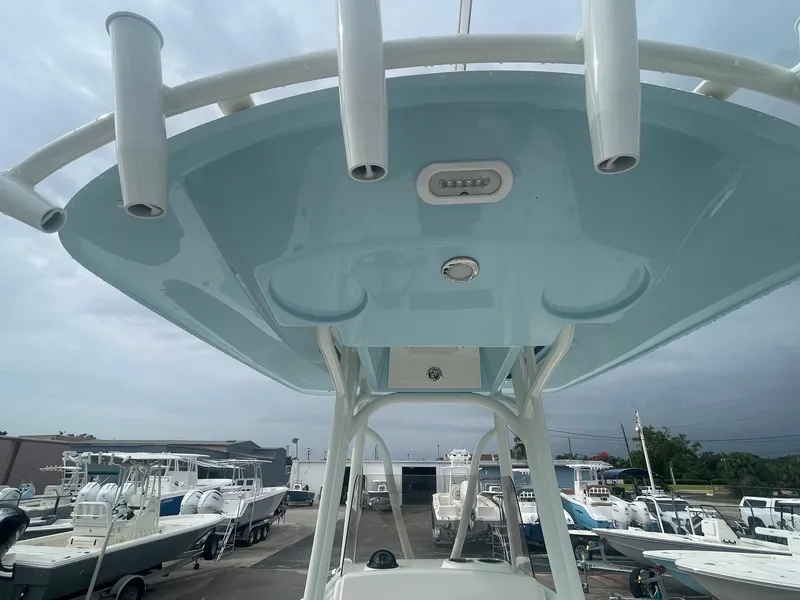 Slide: The Image of 2025 Pathfinder 2400 TRS boat with T-top, docked among other boats. - 5