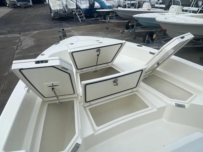 Slide: The Image of 2025 Pathfinder 2400 TRS boat with open storage compartments, docked in a marina. - 6
