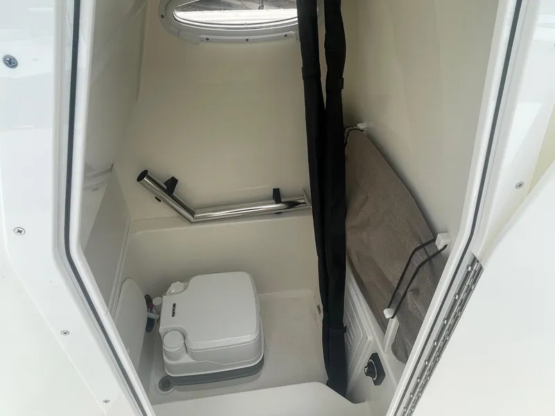 Slide: The Image of 2025 Pathfinder 2400 TRS boat interior with compact toilet and storage area. - 7