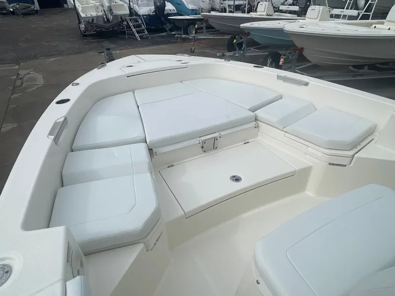 Slide: The Image of 2025 Pathfinder 2400 TRS boat interior with white cushioned seating in a marina setting. - 9