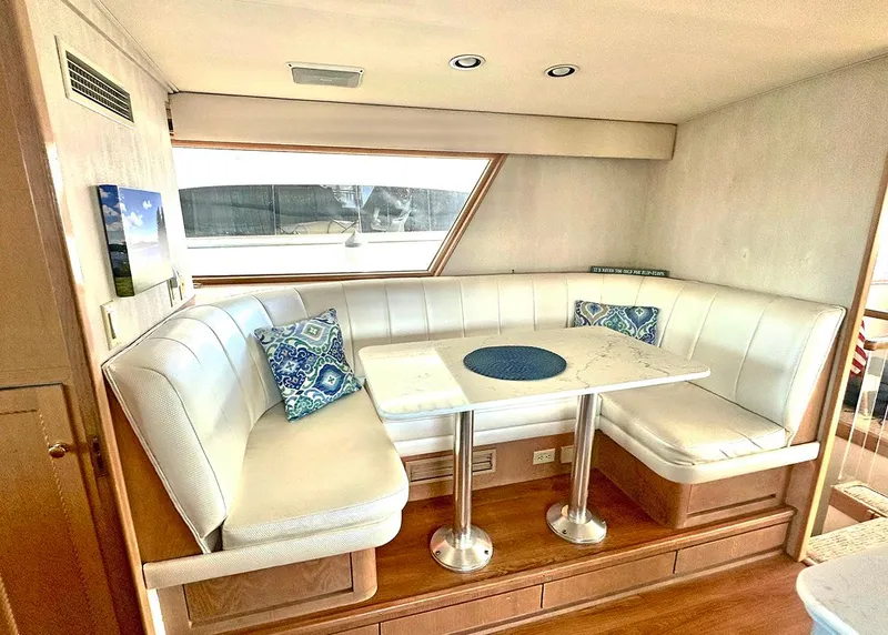 Slide: The Image of 1994 Hatteras Cockpit Motoryacht interior with white leather seating and decorative pillows. - 10