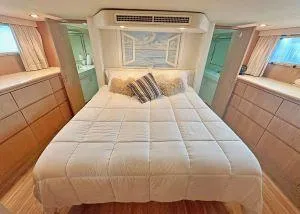 Slide: The Image of 1994 Hatteras Cockpit Motoryacht bedroom with cozy bed and nautical decor. - 17