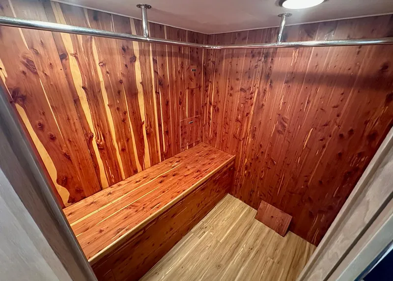 Slide: The Image of Cedar-lined closet interior on 1994 Hatteras Cockpit Motoryacht, featuring wooden bench and hanging rods. - 24