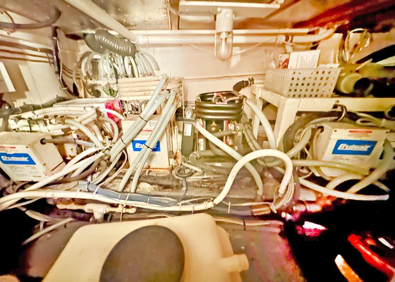 Slide: The Image of Engine room of a 1994 Hatteras Cockpit Motoryacht with complex wiring and machinery. - 32
