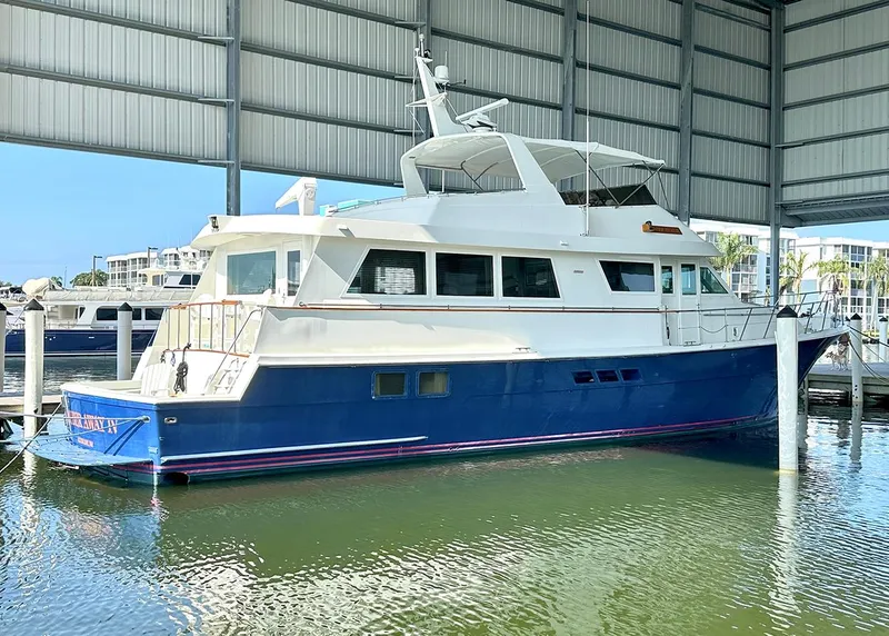 Slide: The Image of 1994 Hatteras Cockpit Motoryacht docked in a covered marina. - 36