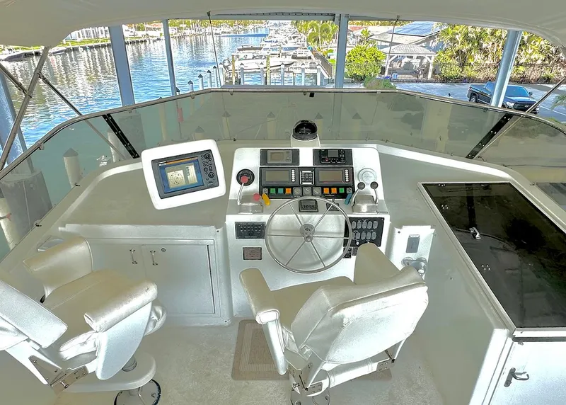 Slide: The Image of 1994 Hatteras Cockpit Motoryacht helm with navigation equipment and marina view. - 4