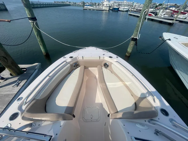 Slide: The Image of 2014 Grady-White Freedom 255 boat docked at marina, featuring spacious seating area. - 10