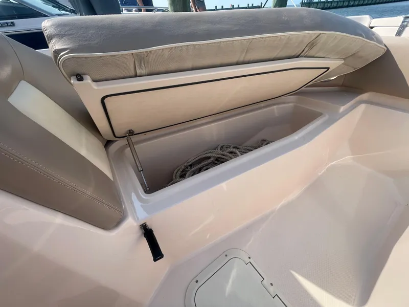 Slide: The Image of 2014 Grady-White Freedom 255 boat storage compartment with open seat revealing rope inside. - 11