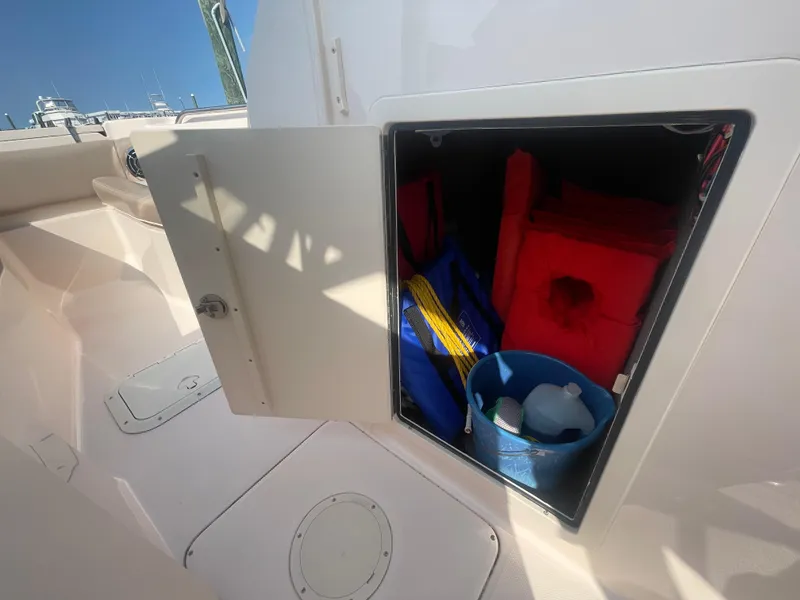 Slide: The Image of 2014 Grady-White Freedom 255 boat storage compartment with life jackets and cleaning supplies. - 14
