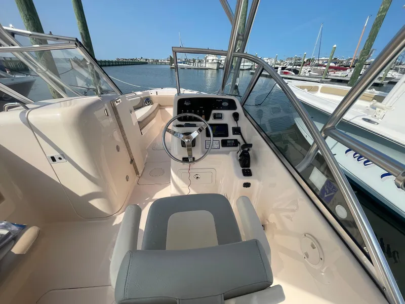Slide: The Image of 2014 Grady-White Freedom 255 boat cockpit with steering wheel, docked at marina. - 16
