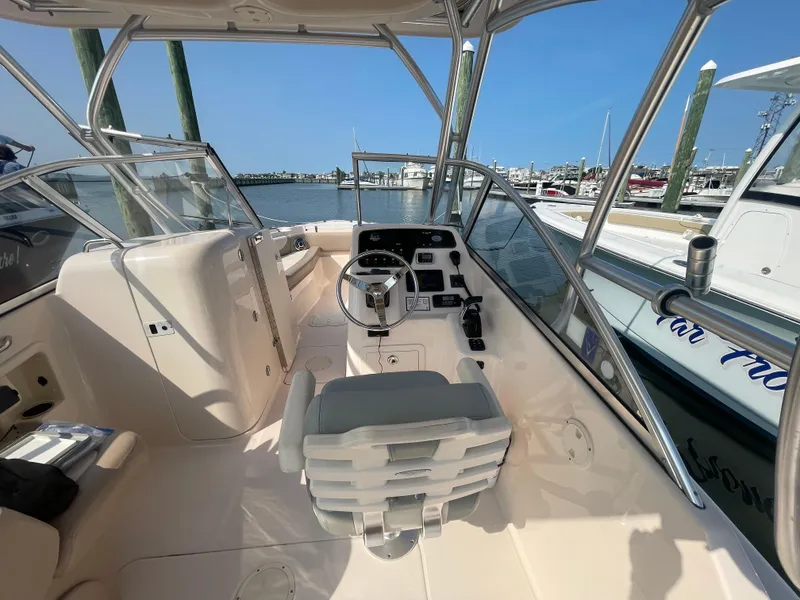 Slide: The Image of 2014 Grady-White Freedom 255 boat interior with helm, docked at marina. - 17