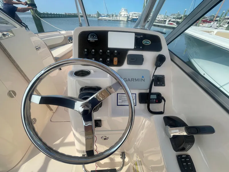 Slide: The Image of 2014 Grady-White Freedom 255 boat helm with Garmin navigation system and steering wheel. - 19