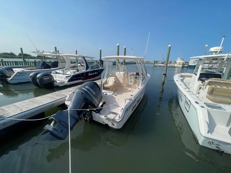 Slide: The Image of 2014 Grady-White Freedom 255 boat docked at marina, clear blue sky. - 2
