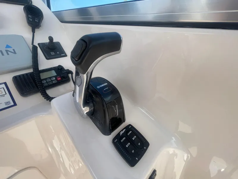 Slide: The Image of 2014 Grady-White Freedom 255 boat controls with throttle and communication equipment. - 23