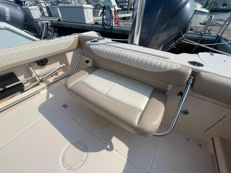 Slide: The Image of 2014 Grady-White Freedom 255 boat interior with beige seating and docked in a marina. - 35