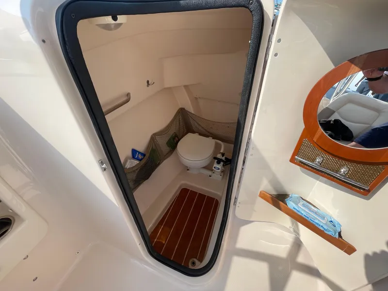 Slide: The Image of 2014 Grady-White Freedom 255 boat interior with compact bathroom and wooden flooring. - 42