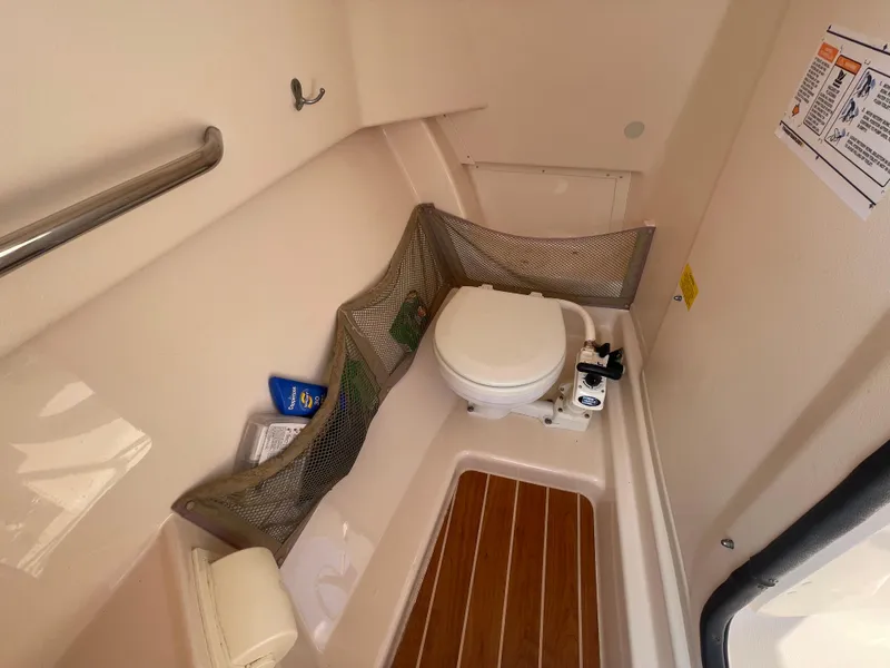 Slide: The Image of 2014 Grady-White Freedom 255 boat interior with toilet and storage netting. - 43