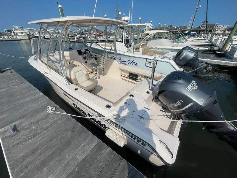 Slide: The Image of 2014 Grady-White Freedom 255 boat docked, featuring dual Yamaha engines, in a marina setting. - 5