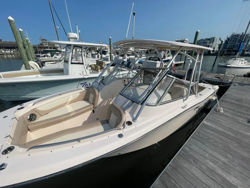 Slide: The Image of 2014 Grady-White Freedom 255 boat docked at marina under clear blue sky. - 6