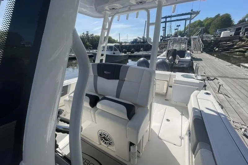 Slide: The Image of 2023 Robalo R270 Center Console boat docked at marina, featuring sleek seating and console design. - 11