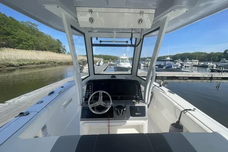 Slide: The Image of 2023 Robalo R270 Center Console boat interior at a marina dock. - 13