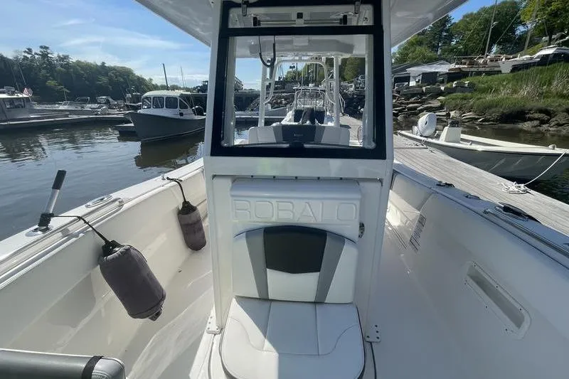 Slide: The Image of 2023 Robalo R270 Center Console boat docked, showcasing sleek design and spacious interior. - 20