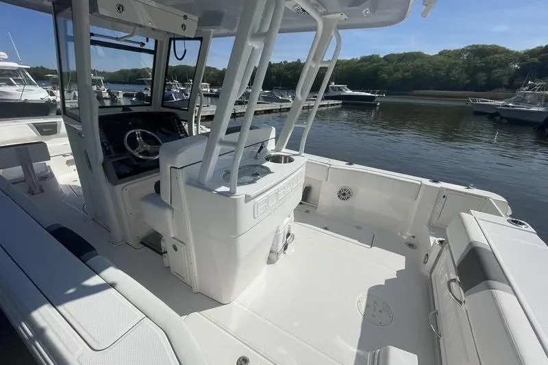 Slide: The Image of 2023 Robalo R270 Center Console boat interior at marina, showcasing helm and seating. - 8