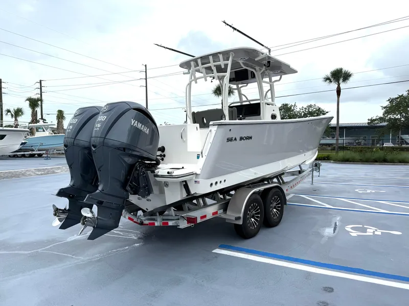 Slide: The Image of 2025 Sea Born SX281 boat on trailer with dual Yamaha engines in parking lot. - 23