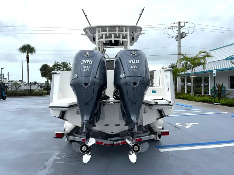 Slide: The Image of 2025 Sea Born SX281 boat with twin 300 V6 engines, parked in a lot. - 24