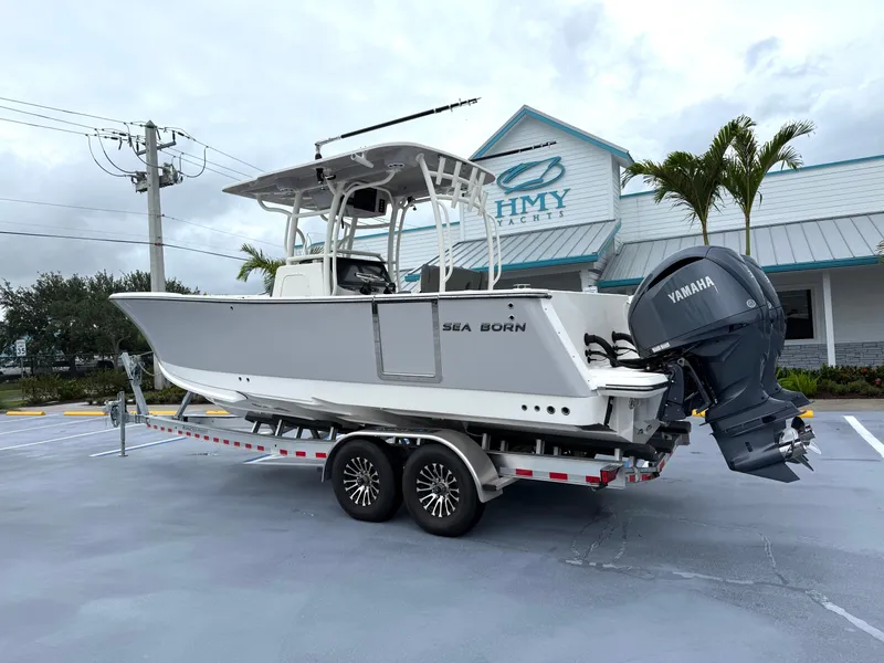 Slide: The Image of 2025 Sea Born SX281 boat on trailer, parked outside dealership with Yamaha engine. - 25