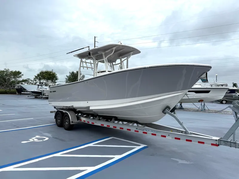 Slide: The Image of 2025 Sea Born SX281 boat on trailer in parking lot, overcast sky. - 3