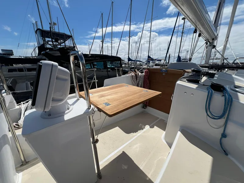 Slide: The Image of Sailboat cockpit of 2025 Tartan 395 with wooden table, marina background. - 2