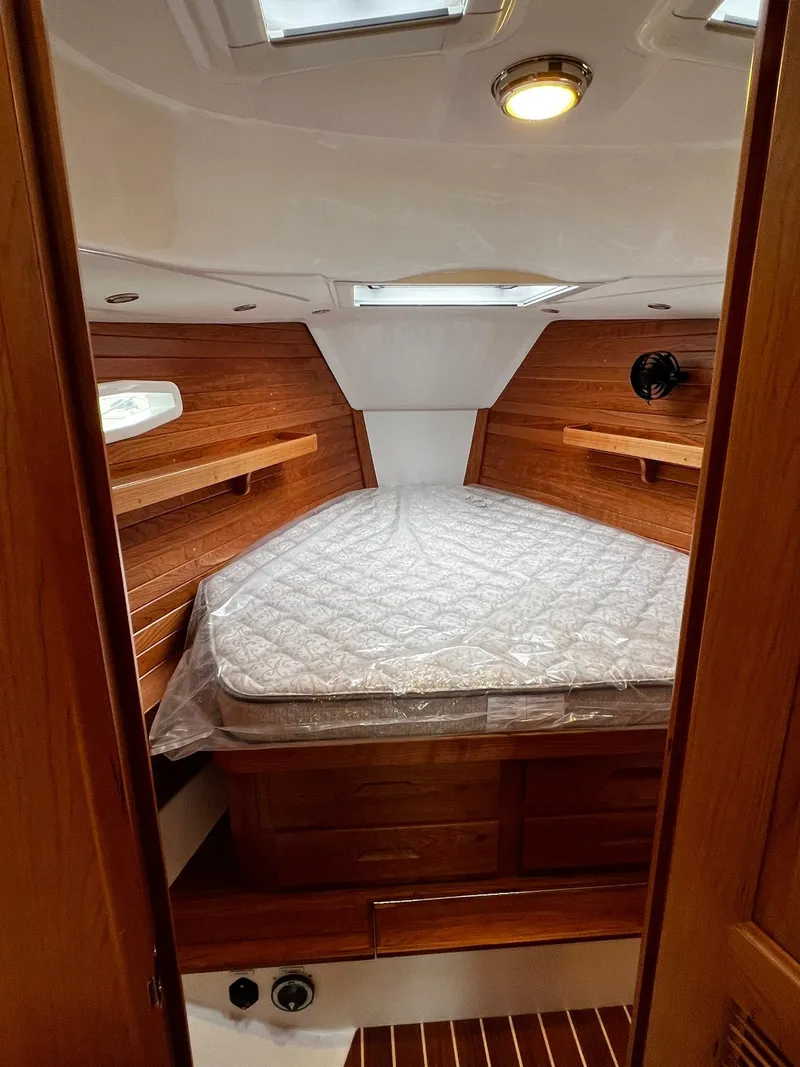 Slide: The Image of 2025 Tartan 395 yacht cabin with wooden interior and cozy bed. - 20