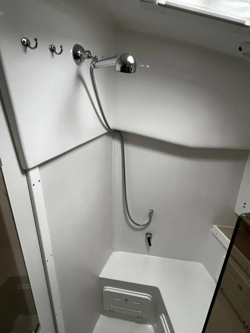 Slide: The Image of Compact shower area in a 2025 Tartan 395 yacht, featuring modern fixtures and white interior. - 23