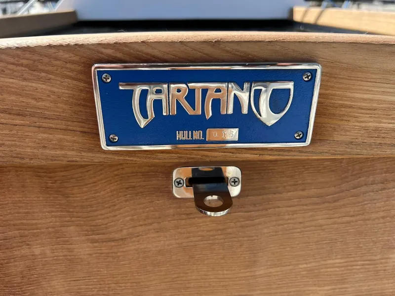 Slide: The Image of Tartan 395 boat nameplate on wooden surface, model year 2025. - 31