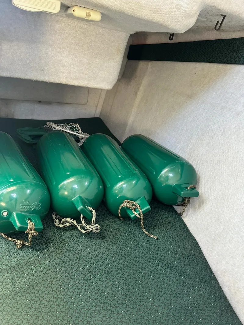 Slide: The Image of 2004 Trophy 2359 Hardtop boat interior with white cushioned seating and storage compartments. - 37