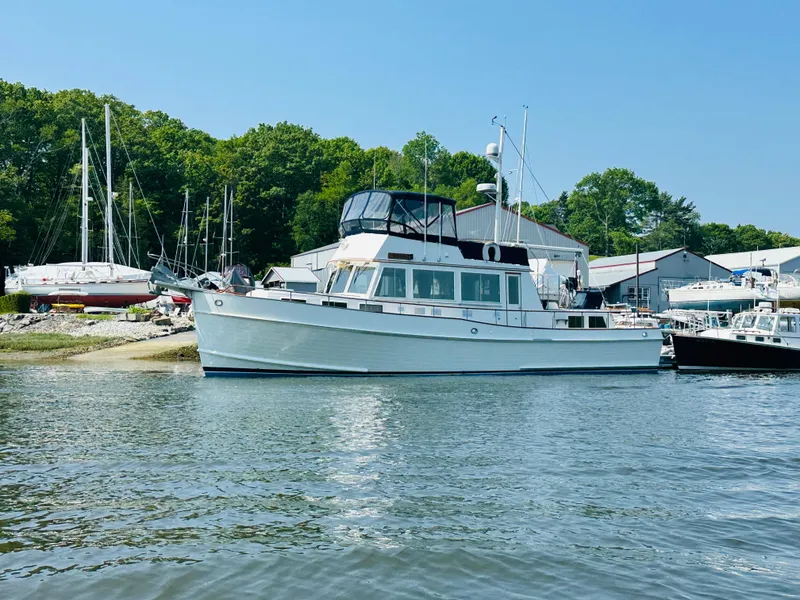The Image of 1998 Grand Banks 49 Classic yacht docked near a marina with trees in the background. - 0