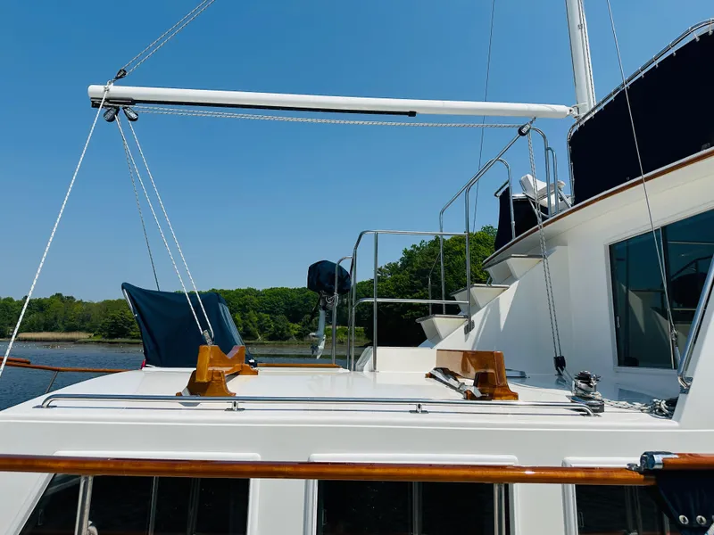 Slide: The Image of 1998 Grand Banks 49 Classic yacht deck with clear blue sky and lush greenery. - 10