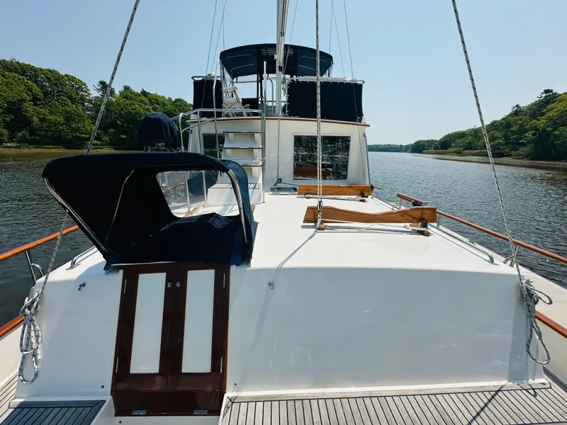 Slide: The Image of 1998 Grand Banks 49 Classic yacht on a serene river, showcasing its spacious deck and elegant design. - 11