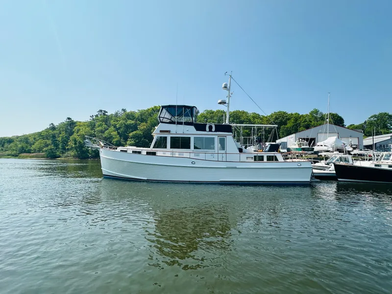 Slide: The Image of 1998 Grand Banks 49 Classic yacht docked on calm water, surrounded by greenery. - 2