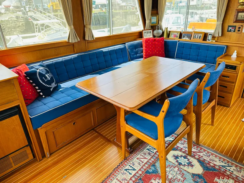 Slide: The Image of Interior of 1998 Grand Banks 49 Classic yacht with blue seating and wooden dining table. - 22