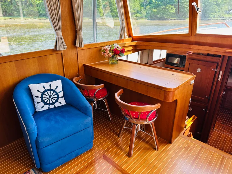 Slide: The Image of Interior of 1998 Grand Banks 49 Classic yacht with blue chair and wooden table. - 27