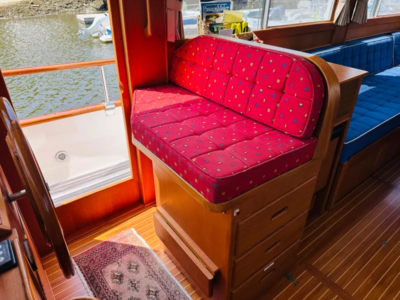 Slide: The Image of Interior of 1998 Grand Banks 49 Classic with red cushioned seating and wooden flooring. - 29