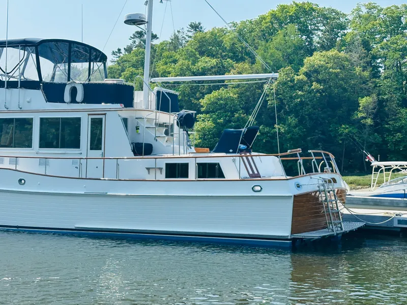 Slide: The Image of 1998 Grand Banks 49 Classic yacht docked by lush green trees. - 4