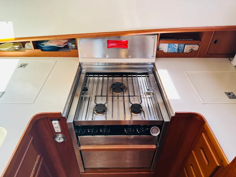 Slide: The Image of 1998 Grand Banks 49 Classic yacht kitchen with stainless steel stove and wooden cabinetry. - 40