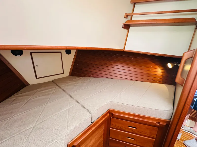 Slide: The Image of 1998 Grand Banks 49 Classic cabin with wooden interior and cozy bed. - 50